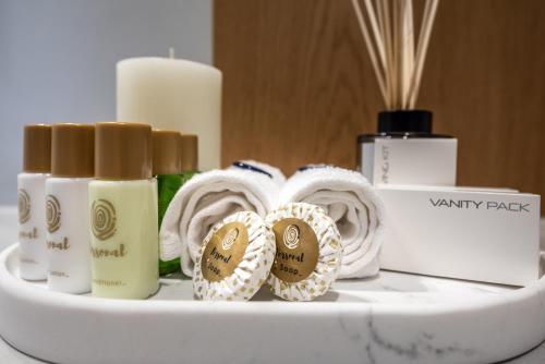 a shelf with three bottles of soap and towels at Ariadne Suites in Mytakas