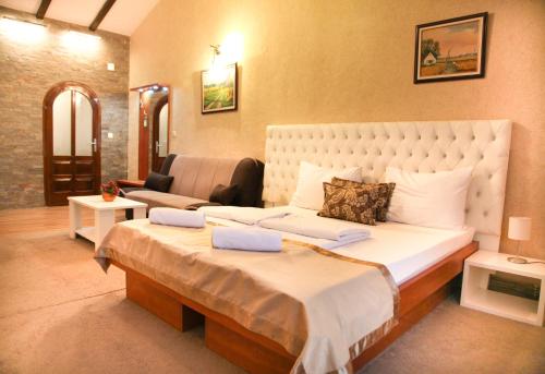 a bedroom with a large bed and a living room at S Club Resort Hotel Aqua Park and Spa in Belgrade