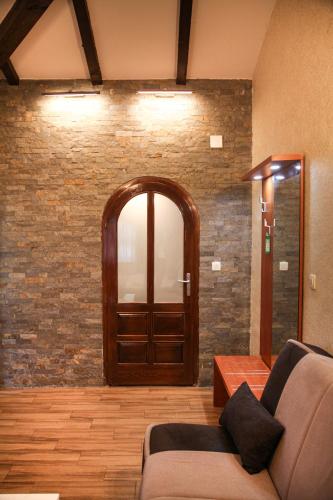a living room with a couch and a wooden door at S Club Resort Hotel Aqua Park and Spa in Belgrade