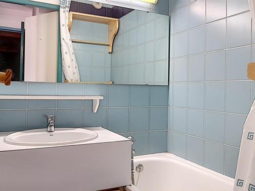 une salle de bain avec un lavabo et une baignoire dans l'établissement Appartement cosy au pied des pistes avec balcon – 5 personnes, 32 m² - FR-1-344-1026, aux Menuires