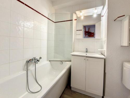 une salle de bain blanche avec une baignoire et un lavabo dans l'établissement Studio lumineux Proche des pistes Balcon - FR-1-344-1035, aux Menuires