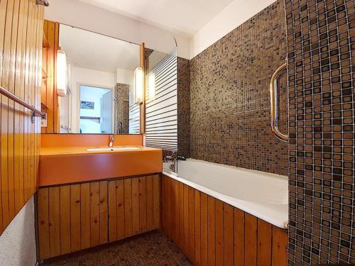une salle de bain avec un lavabo, une baignoire et un miroir dans l'établissement Appartement cosy, 4 pers, balcons, aux pieds des pistes - FR-1-344-1044, aux Menuires