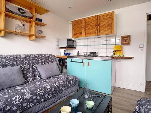 un salon avec un canapé et une cuisine dans l'établissement Studio cosy au pied des pistes, 2 pers, centre, ski, animaux admis - FR-1-344-1010, aux Menuires