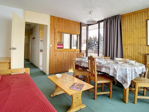 une salle à manger avec une table et des chaises dans l'établissement Appartement spacieux, skis aux pieds, balcon, Les Menuires - FR-1-344-1054, aux Menuires