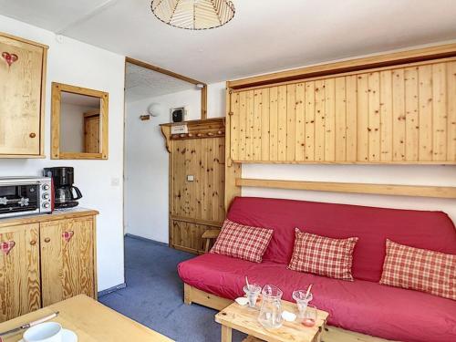 un salon avec un canapé rouge et une table dans l'établissement Studio cosy pour 2 au cœur de La Croisette, accès pistes à 150m - FR-1-344-1029, aux Menuires