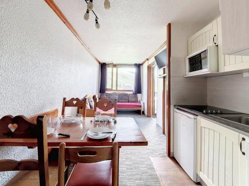 - une cuisine et une salle à manger avec une table en bois dans l'établissement Appartement Rénové · Balcon Sud-Ouest · Proche Pistes · 2 Pièces · 4 Couchages - FR-1-344-1042, aux Menuires