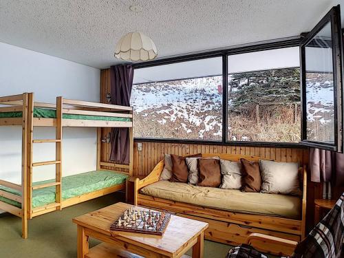 - un salon avec un canapé et des lits superposés dans l'établissement Appartement skis aux pieds avec balcon et 2 chambres - FR-1-344-1037, aux Menuires