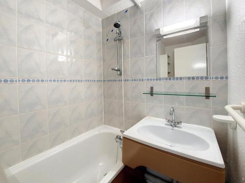 une salle de bain avec un lavabo, une baignoire et un miroir dans l'établissement Studio confortable proche des pistes avec balcon et cuisine équipée - FR-1-344-1043, aux Menuires