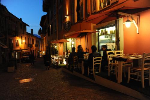 a group of people sitting at a restaurant at night at Casa Botta - Luino Lago Maggiore in Luino
