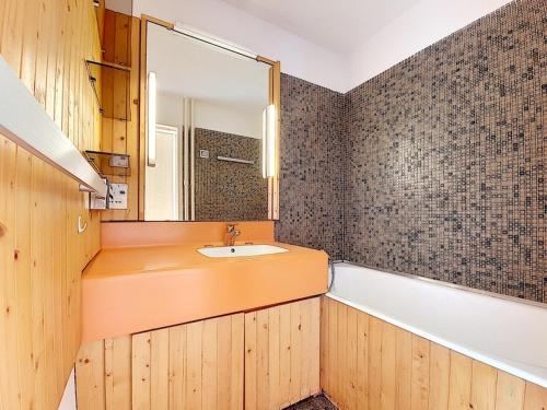 une salle de bain avec un lavabo, une baignoire et un miroir dans l'établissement Appartement lumineux au cœur de la station avec balcon sud, accès direct aux pistes, 5 pers. - FR-1-344-1059, aux Menuires