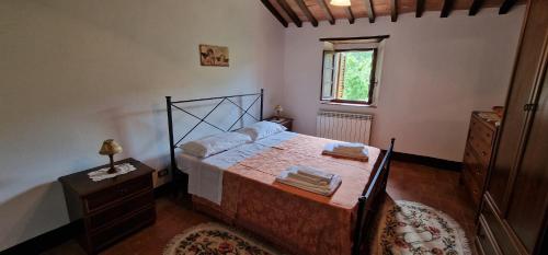 1 dormitorio con cama y ventana en AGRITURISMO LA PIAGGIA appartamenti a Vivo D'Orcia, en Vivo dʼOrcia