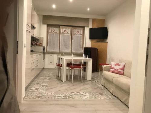 a kitchen and living room with a table and a couch at A CASA DI LETY in Tarvisio