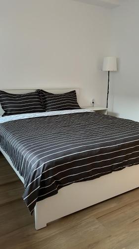 1 cama con edredón blanco y negro y lámpara en Accommode en Sinaia