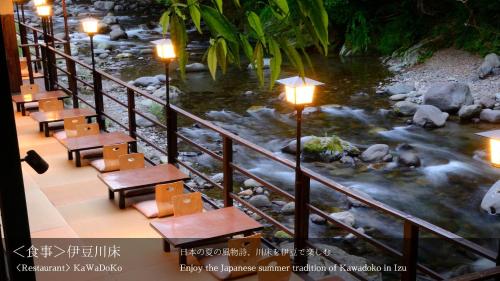 a view of a river with tables and lights at Tatsuta Ryokan in Izu