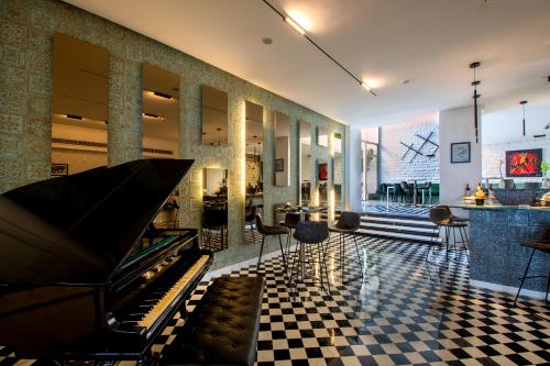 a lobby with a piano on a checkered floor at Riviera Hotel and Beach Lounge, Beirut in Beirut