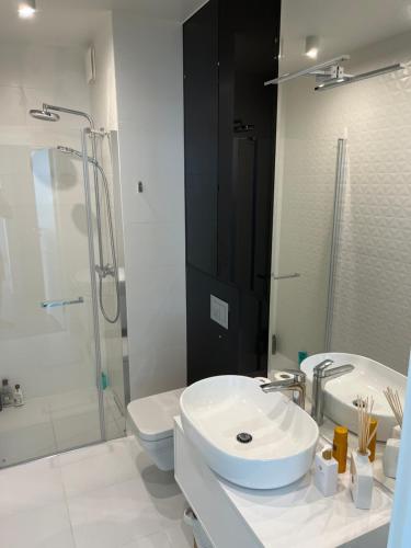 a bathroom with a sink and a toilet and a shower at Wave Resort & Spa Magic Apartaments with sea view in Międzyzdroje