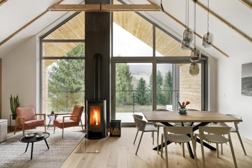 a living room with a table and a fireplace at Korona Bieszczad in Wetlina