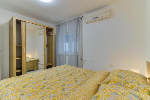 een slaapkamer met een bed met een gele deken bij Demi II in Senj