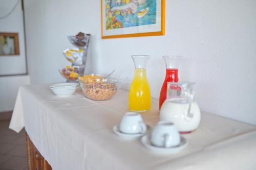 a table with two bottles of orange juice and cups at Hotel Baia Delle Sirene in Taormina