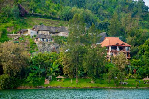 a house on a hill next to a body of water at Hakuna Matata Lodge in Gisenyi