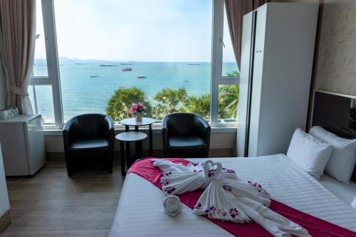 a hotel room with a bed with a view of the ocean at The Beach Front Resort, Pattaya in Pattaya
