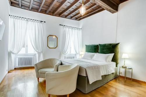 - une chambre blanche avec un lit et une chaise dans l'établissement Domus Sant'Angelo, à Rome