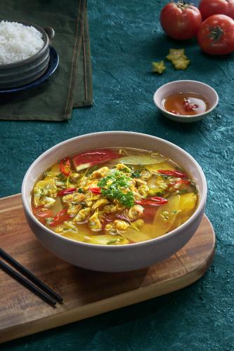 a bowl of soup on a cutting board with rice at Canary Dalat Hotel in Da Lat