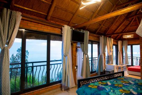 a bedroom with a bed and a large window at Hakuna Matata Lodge in Gisenyi