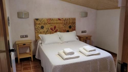 1 dormitorio con 1 cama blanca y 2 toallas en VENTA DE LA CASA NOGUERA en Riópar