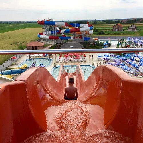 a boy rides a water slide at a water park at S Club Resort Hotel Aqua Park and Spa in Belgrade