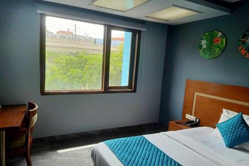 a bedroom with a bed and a window and a desk at Asian Suites IFFCO Metro Station Gurugram in Gurgaon