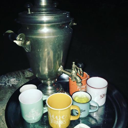 a table with a coffee pot and cups on it at Berkri Gastro Yard & Guest House in Yenokavan