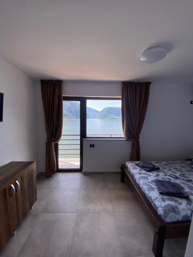 ein Schlafzimmer mit Bett und Blick aufs Wasser in der Unterkunft Vila Levitas in Dubova