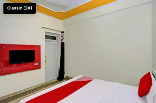 a bedroom with a bed and a tv on the wall at Hotel NK guesthouse in Sikandra
