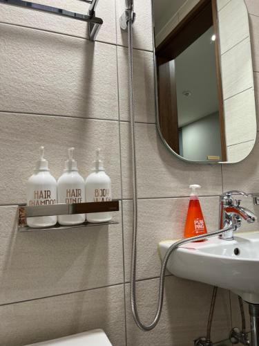 a bathroom with a sink and a toilet and a mirror at Hao Guesthouse in Hongdae in Seoul