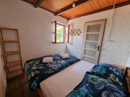 sypialnia z dużym łóżkiem i oknem w obiekcie Robinson house Ruža w mieście Neviđane