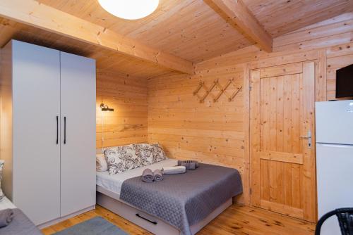 a bedroom with a bed in a wooden cabin at Kunigiškės, svečių namai in Palanga