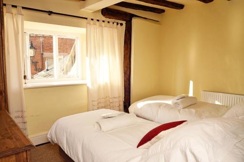 2 camas en una habitación con ventana en Trade Digs High Street, en Stroud