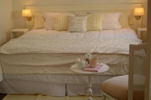 Una cama blanca con una bandeja con dos tazas. en A & E Buenos Aires en Buenos Aires