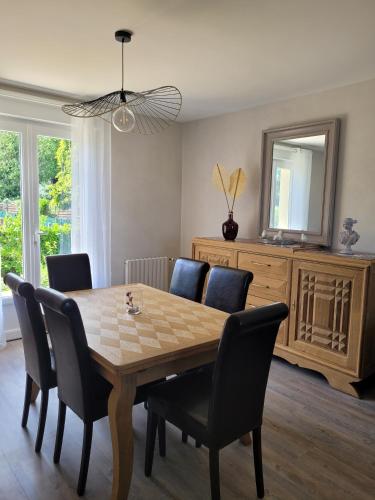 une salle à manger avec une table, des chaises et un miroir dans l'établissement La Mosloise, à Mosles