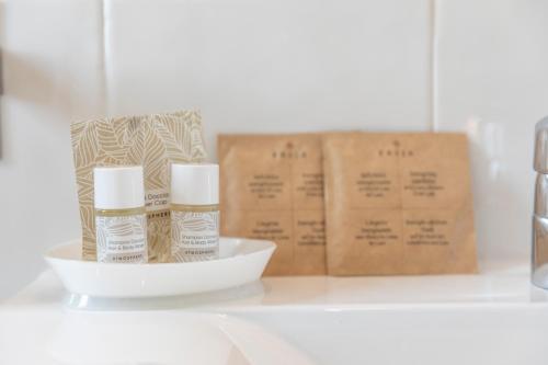 a shelf with two bottles of essential oils and boxes at Hotel Loretta & Dependance in Cervia