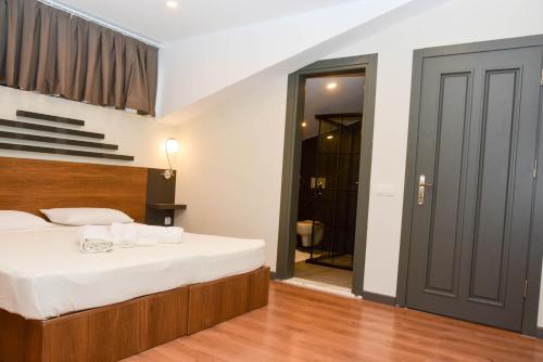 a bedroom with a large bed and a bathroom at BEGONVİL VİLLA in Belek