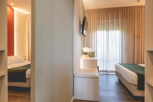 a hotel room with two beds and a window at Hotel Loretta & Dependance in Cervia