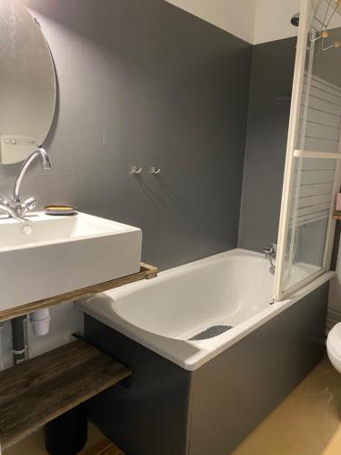W łazience znajduje się umywalka, wanna i lustro. w obiekcie Bel appartement 4 à 6 couchages au pied des pistes à Superbagneres w mieście Saint-Aventin