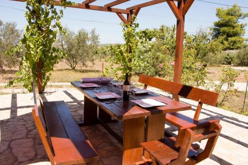 a wooden table and chairs sitting under a wooden pergola at Villa Rosemary Park in Zadar