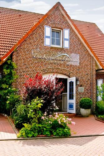 a brick house with flowers in front of it at Landhaus Krabbe von Greetsiel in Greetsiel