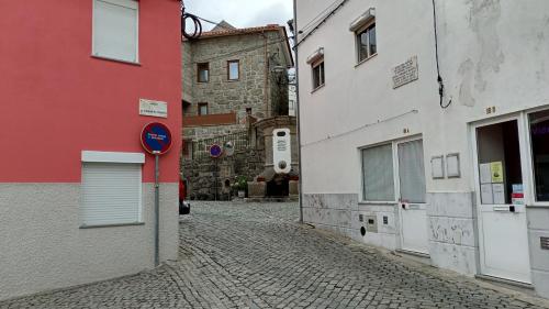 a cobblestone street in an alley between two buildings at Casa do Pelourinho - T1 in Loriga