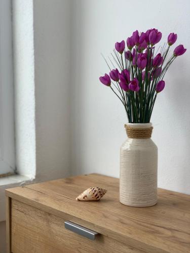 Apartman DMA في تيفات: إناء من الزهور الأرجوانية على طاولة