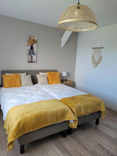 une chambre avec un grand lit avec une couverture jaune dans l'établissement La Mosloise, à Mosles
