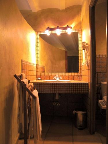 a bathroom with a sink and a large mirror at El Jardín Vertical in Vilafames